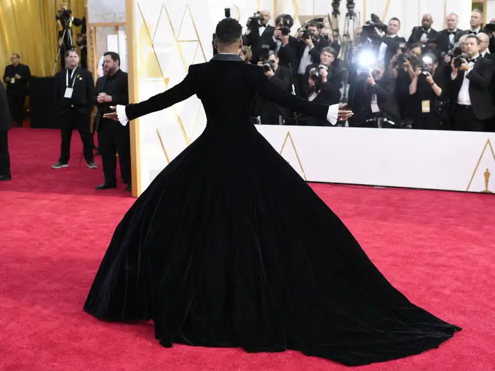 Black velvet tuxedo gown with dramatic train evoking Billy Porter Oscars look in most daring award show outfits ever rankings