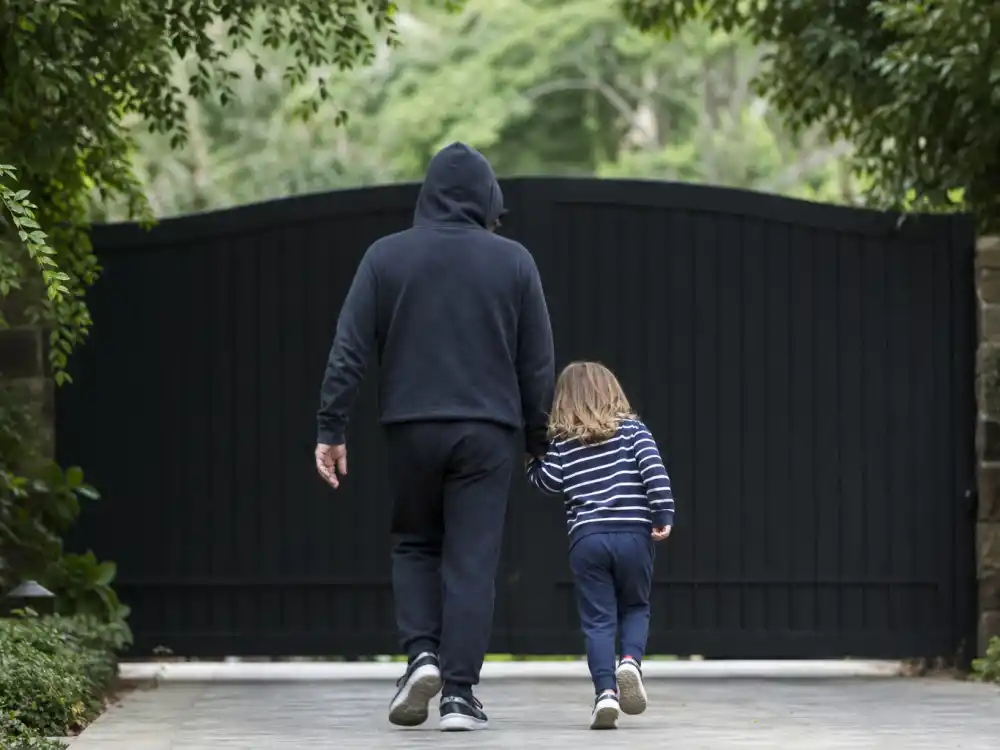 Estate privacy gate with hooded parent and child from behind only for most identical celebrity parent child pairs minor protection editorial standard
