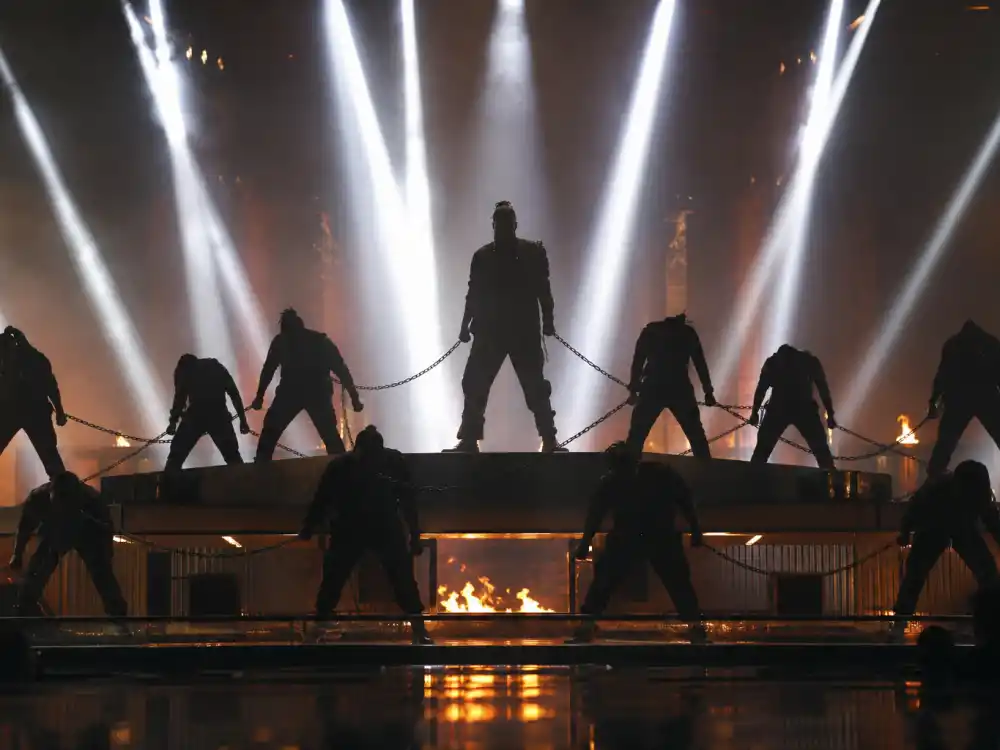 Chained dancer silhouettes under harsh white light mirror Kendrick Lamar political medley staging in most memorable Grammy performances