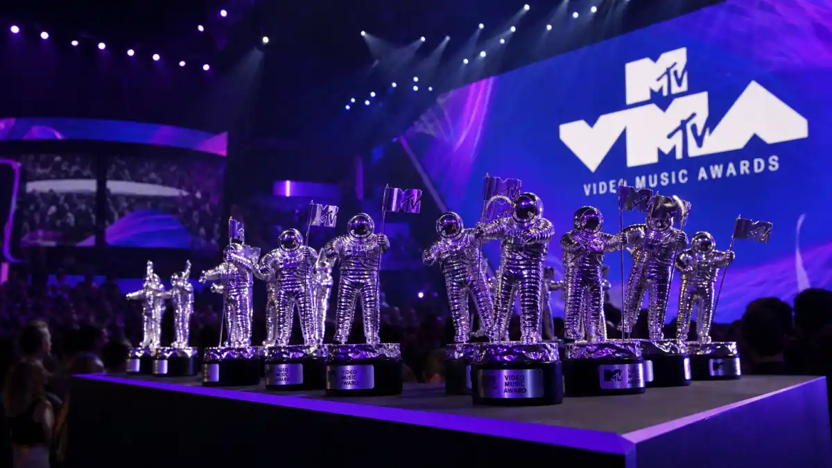 Most VMAs won by an artist — silver MTV Moon Person trophies on VMA stage with purple lighting and Video Music Awards logo screen