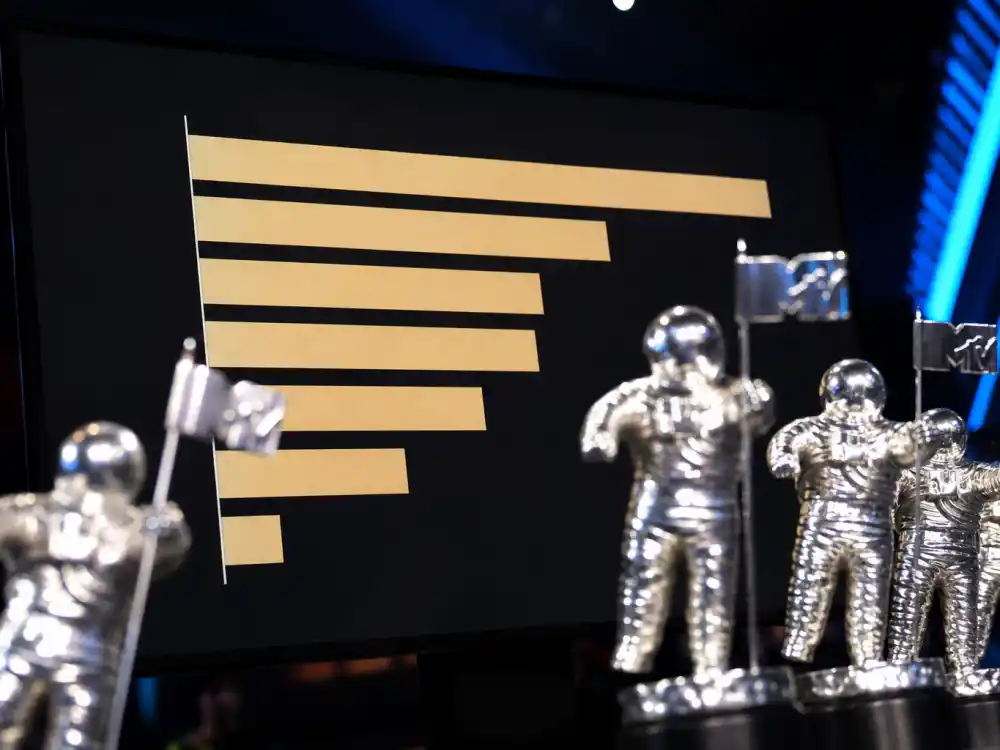 Leaderboard chart tracking the most VMAs won by an artist with silver Moon Person trophies blurred in the foreground