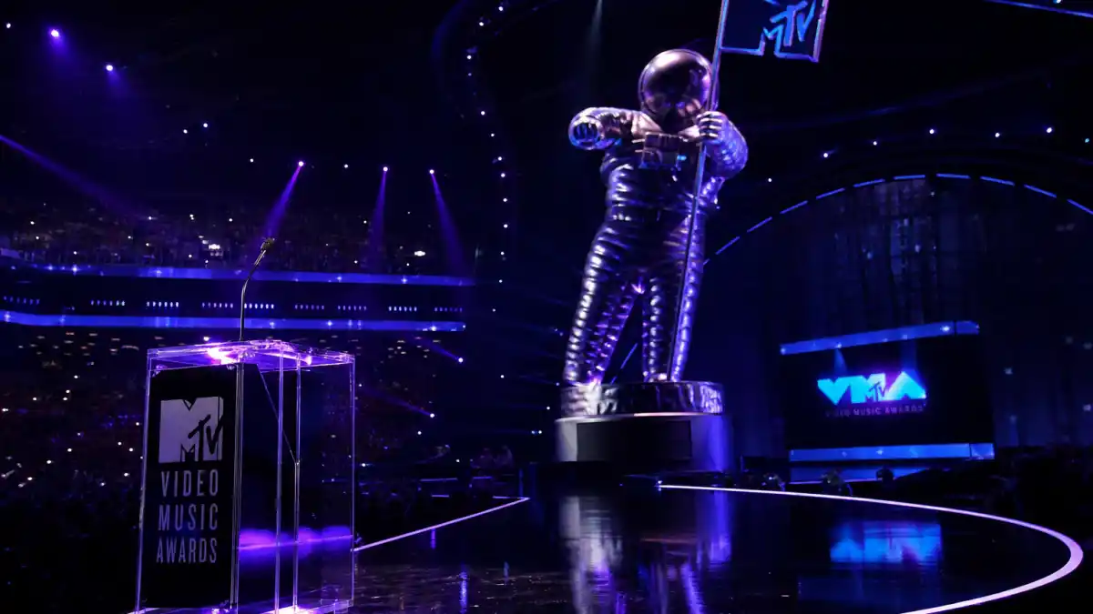 MTV VMAs most iconic moments — Moon Person trophy on dramatic purple awards stage with arena spotlights and live TV atmosphere