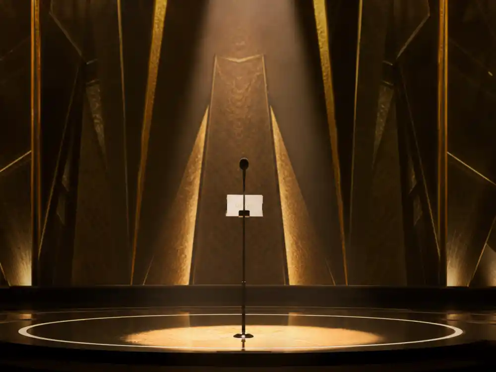 A spotlit awards podium microphone where the best award show opening monologues ever have launched Oscar, Golden Globes, and Grammy telecasts for decades