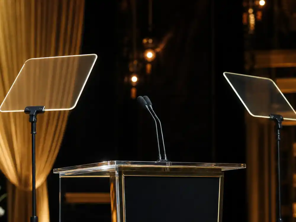 Teleprompter panels beside the podium remind winners that the shortest and longest Oscar speeches ever still share one live-television stage
