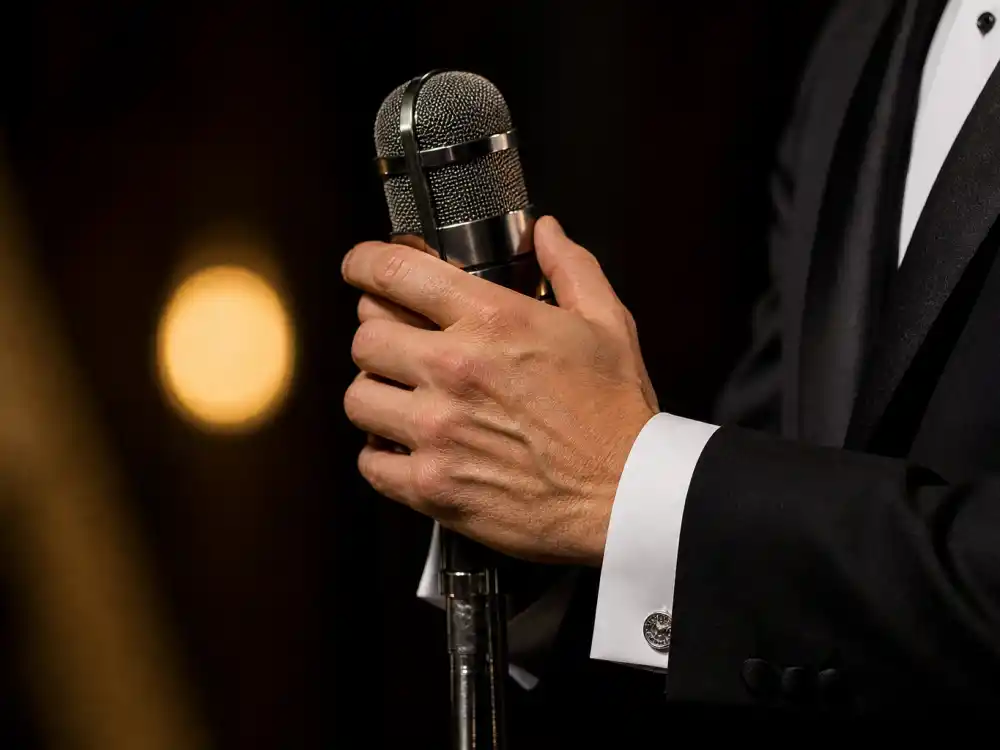 Anonymous hands gripping the awards microphone illustrate emotional beats in the shortest and longest Oscar speeches ever across nine decades