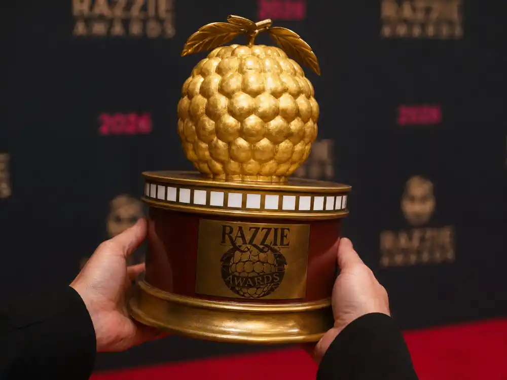 Anonymous hands hold a golden Razzie Awards 2026 worst picture winners statuette after War of the Worlds claimed the top dishonor on Oscar Eve