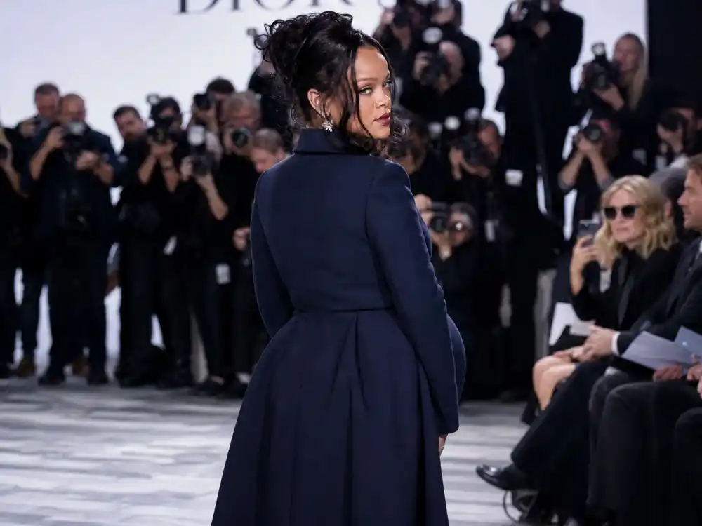 Pregnant woman in navy couture maternity coat at luxury fashion show front row for Rihanna maternity red carpet looks event coverage