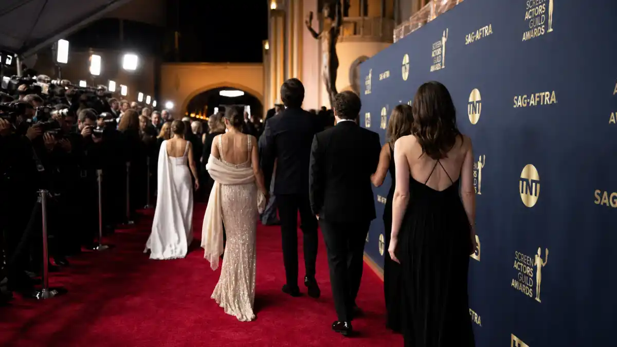SAG Awards best dressed red carpet — Shrine Auditorium arrivals with formal evening gowns and tuxedos under camera flashes March 1 2026