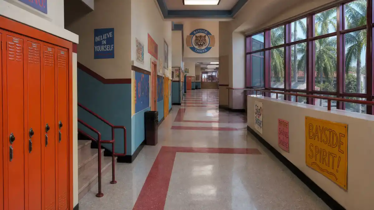 Saved by the Bell cast where are they now — colorful 1990s Bayside High hallway evoking the iconic teen sitcom