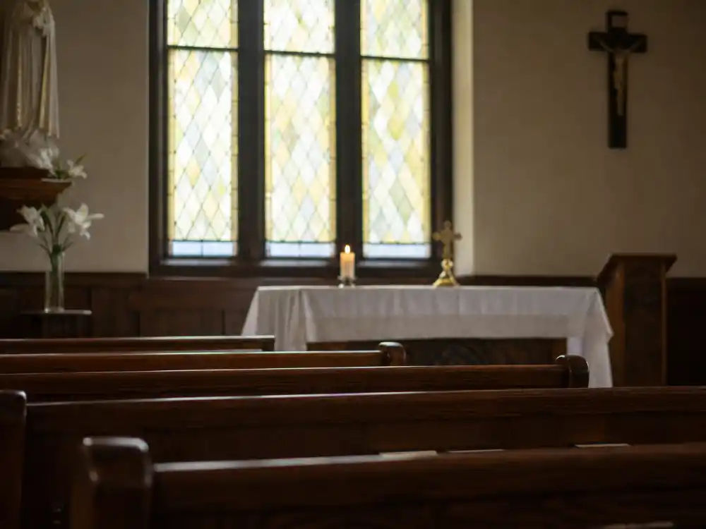 A quiet chapel interior with stained glass representing Shia LaBeouf faith journey and Catholic conversion
