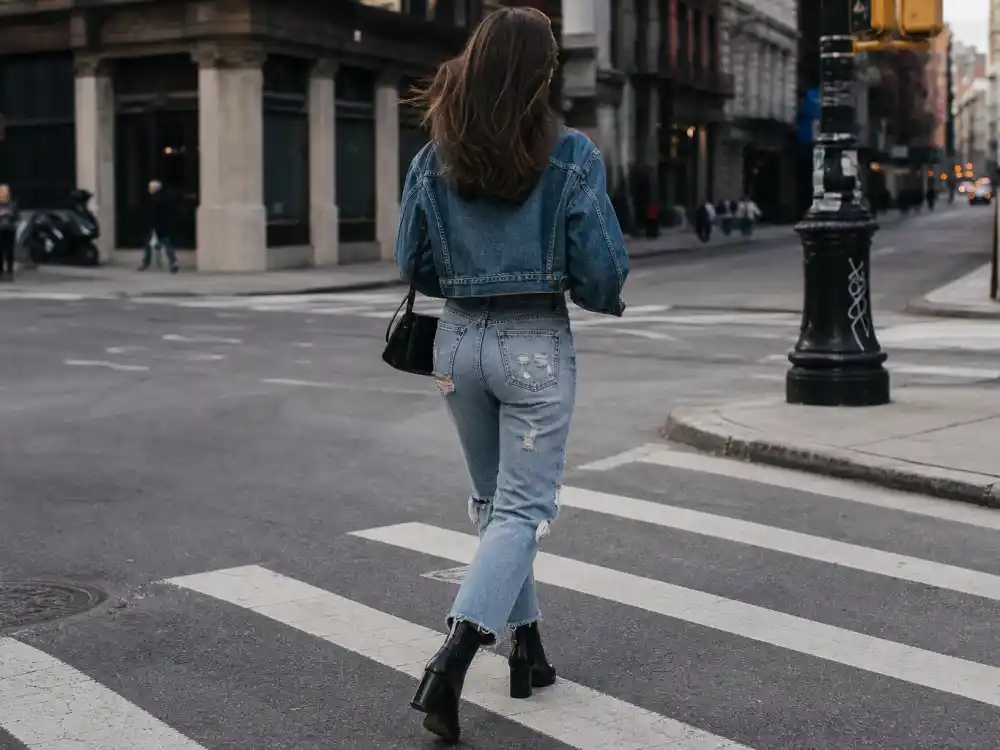 Distressed high-waist straight-leg jeans and black leather ankle boots defining Sophie Turner off duty fashion denim uniform