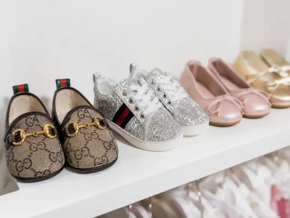 Tiny designer shoes on shelf for Stormi Webster age and personality — luxury kid footwear and red-carpet-ready mini fashion