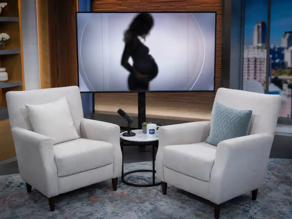 Morning television interview studio for surprise celebrity pregnancy announcements 2025 — broadcast setup suggesting live pregnancy reveal lane beyond Instagram grids