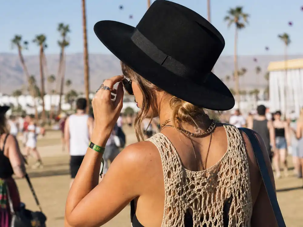 Wide-brim felt hat and round sunglasses over crochet top illustrating Vanessa Hudgens festival street style headwear codes