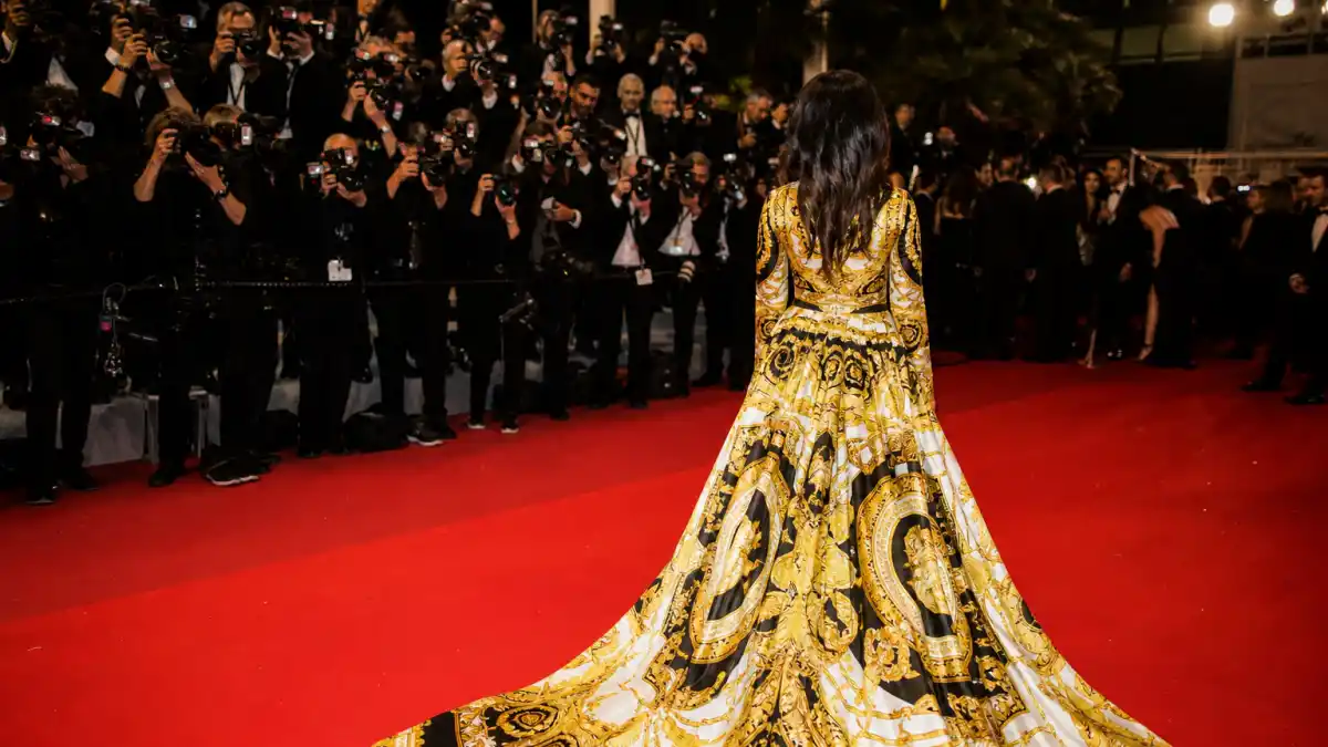 Luxury Versace boutique with gold Medusa logo mannequins in baroque print gowns and gold chain mesh dresses illustrating Versace celebrity red carpet moments culture