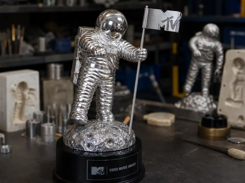 VMA Moon Person trophy history design workshop — close-up of silver astronaut helmet, flag pole, and pedestal craft details