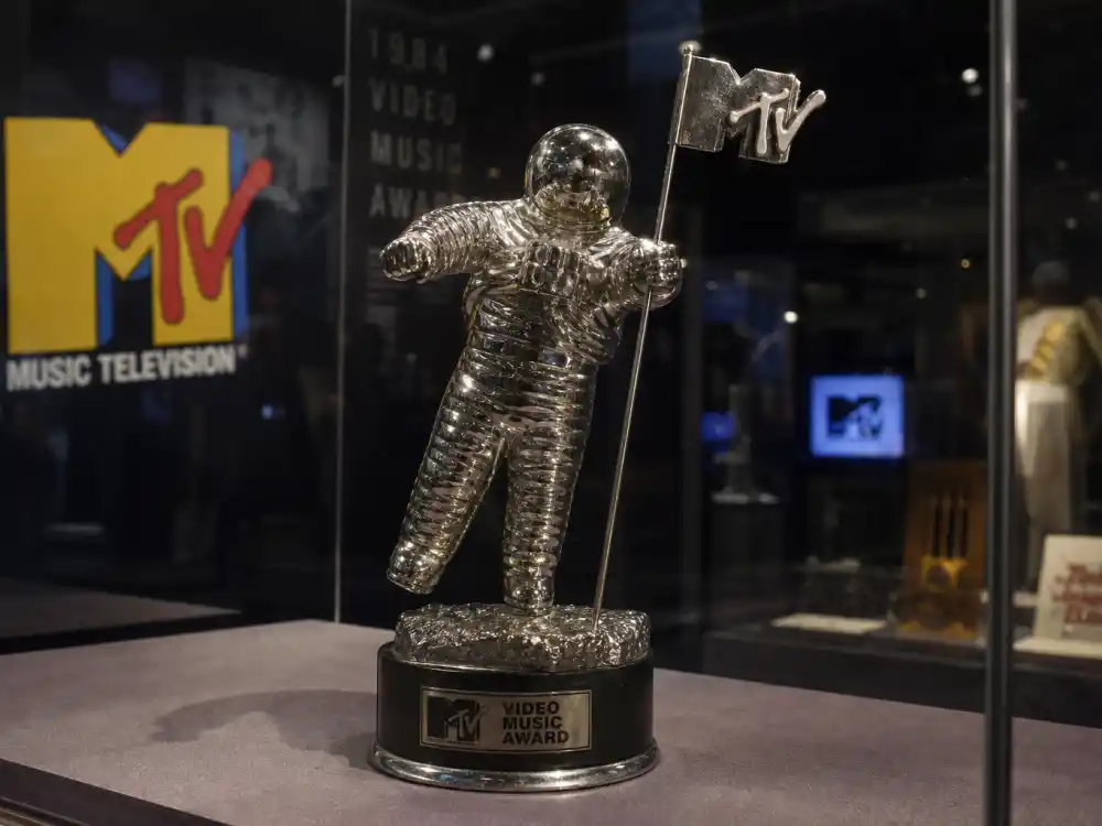 Original MTV Moonman trophy from VMA Moon Person trophy history — vintage 1984 silver astronaut statuette in museum display case