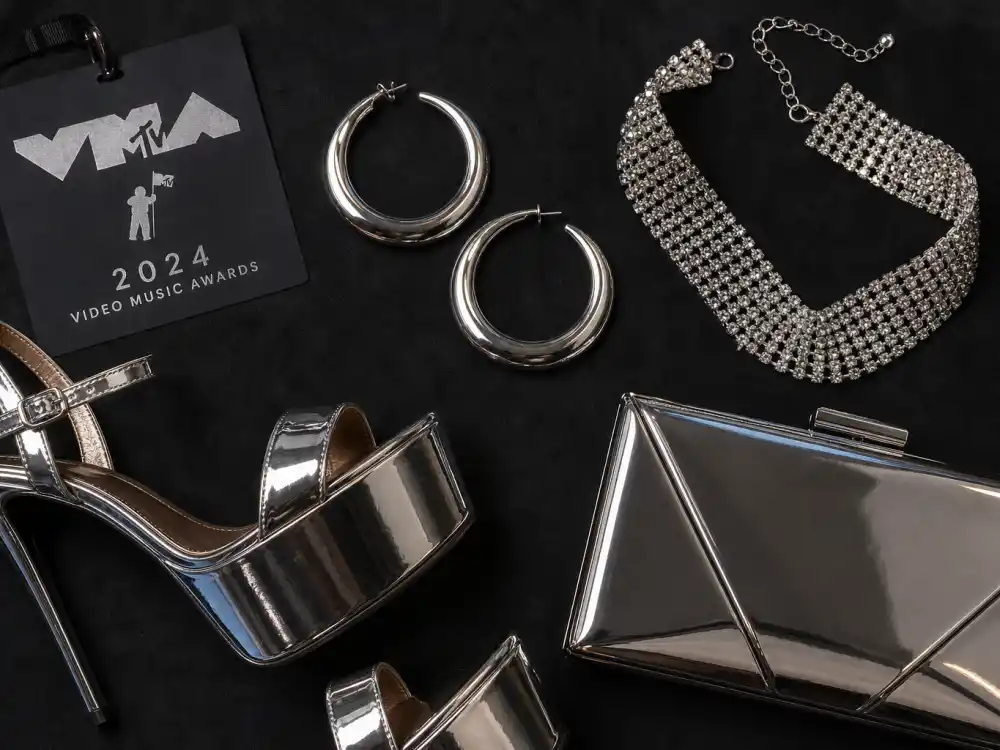 Chunky silver hoop earrings crystal choker platform heels and metallic clutch flat lay finishing vmas celebrity outfits 2026 accessory stacking rules