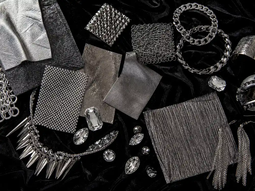 Silver chainmail fabric swatches and crystal embellishments flat lay defining vmas celebrity outfits 2026 edgy red carpet texture foundation