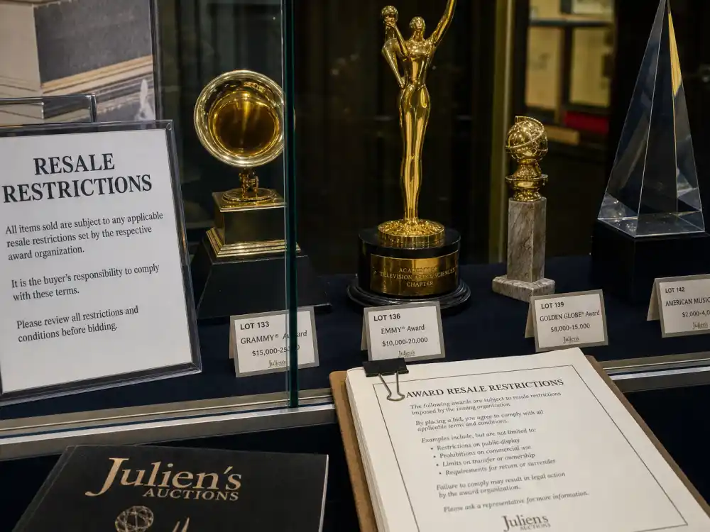 Award trophies in auction display case with legal documents for what are award trophies made of and worth resale rules and buyback policies