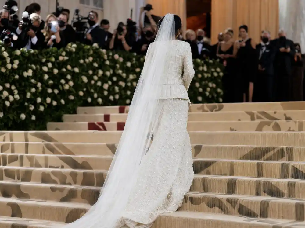 Chanel 1992 bridal tweed gown with veil train on Met Gala steps answering what did Dua Lipa wear to Met Gala 2023