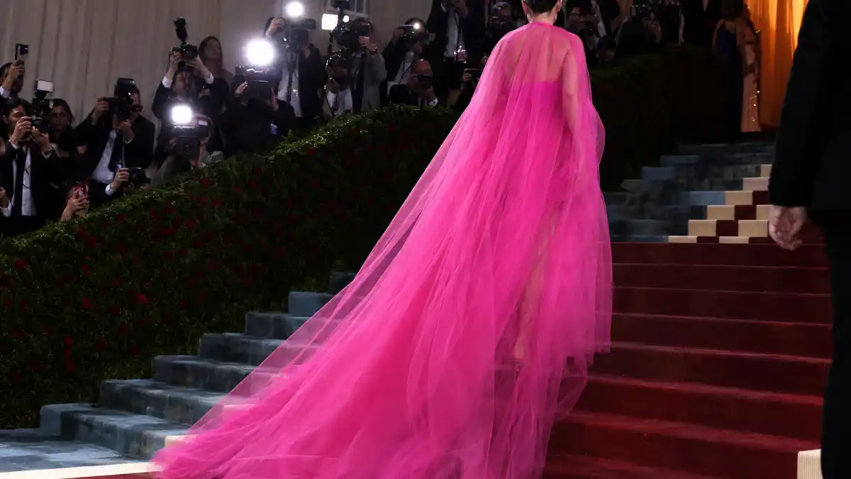 What did Florence Pugh wear to Met Gala — sheer hot-pink Valentino tulle gown on museum steps seen from behind with camera flashes