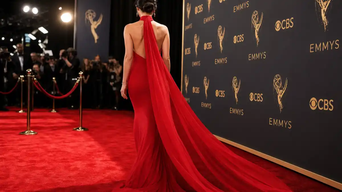 What did Selena Gomez wear to Emmys — cherry-red Louis Vuitton halter column gown with dramatic scarf train on Television Academy red carpet seen from behind