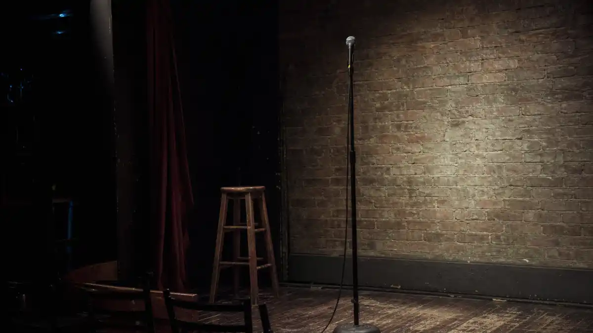 What happened to Andy Dick — empty comedy club stage spotlight evoking his stand-up and sitcom career era