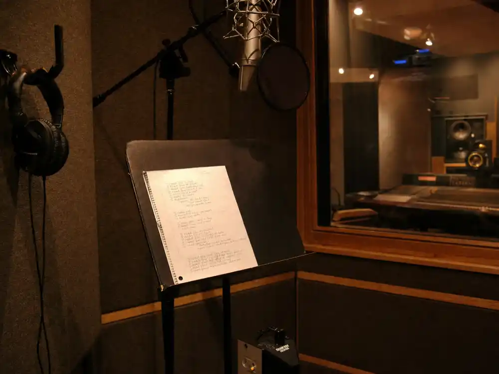 A 2002-era vocal booth with lyric sheet and headphones evoking what happened to Ashanti at her Foolish breakthrough moment