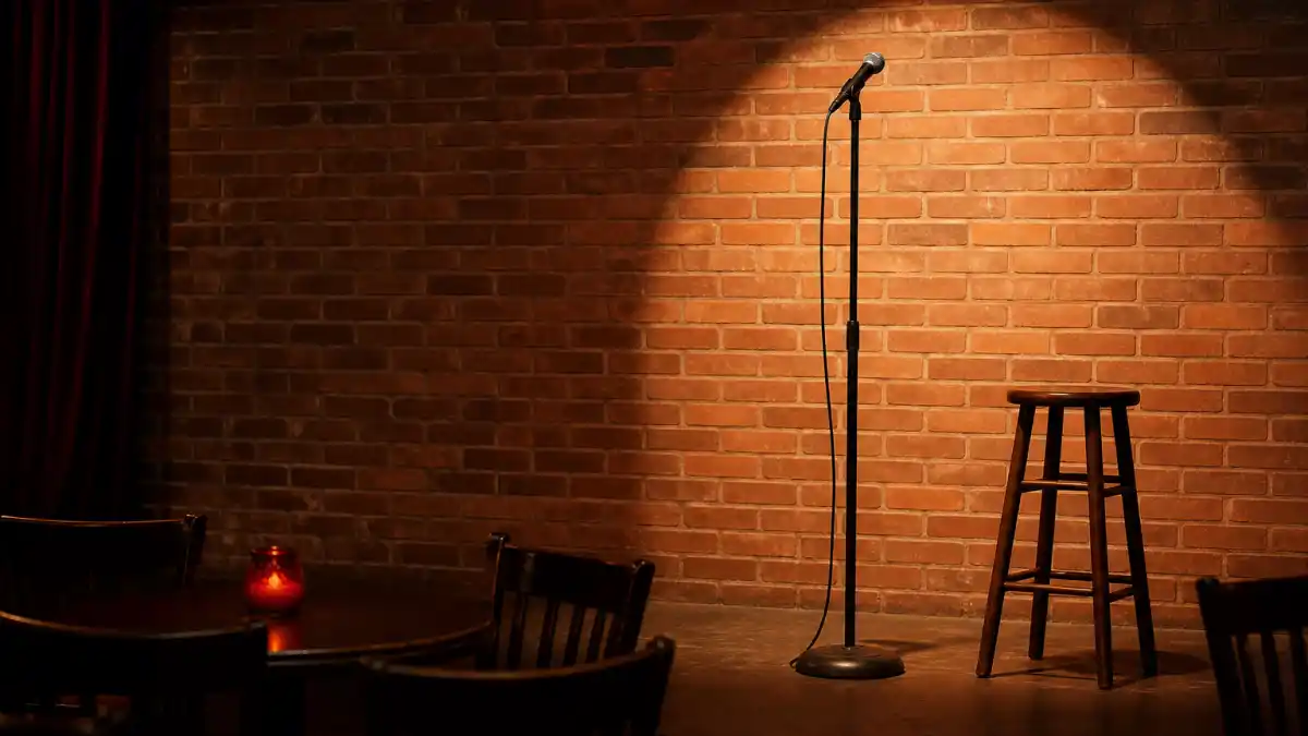 What happened to Carlos Mencia — empty comedy club stage spotlight evoking his stand-up superstar era