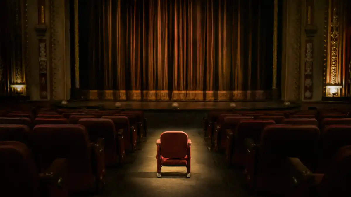 What happened to Jake Lloyd — an empty vintage movie theater with a single small child-sized seat lit by a warm spotlight