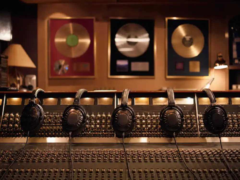 A 1990s pop recording studio with headphones on a mixing console evoking what happened to the Backstreet Boys at their peak fame