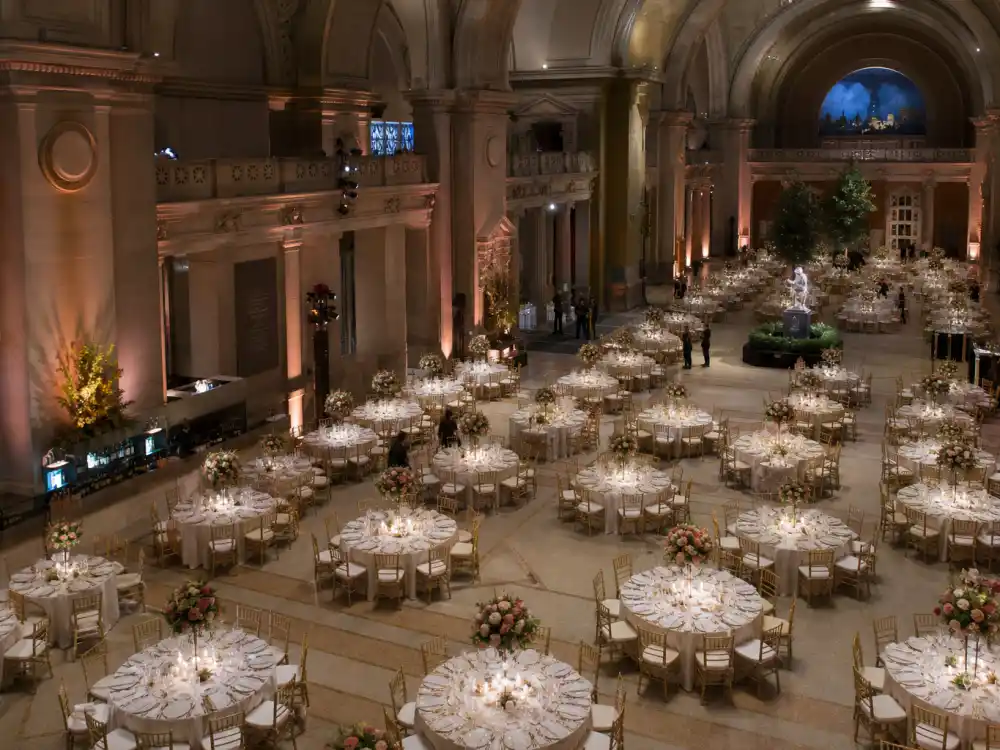 Metropolitan Museum Great Hall gala dinner setup — what happens inside the Met Gala dinner begins with round tables and long banquet rows under crystal chandeliers