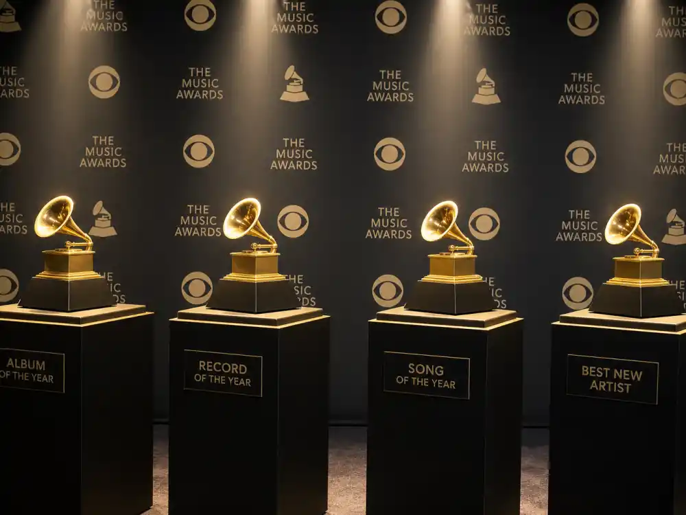 Four golden pedestals on an awards stage illustrate Album Record Song of the Year and Best New Artist in what is the big four Grammy awards