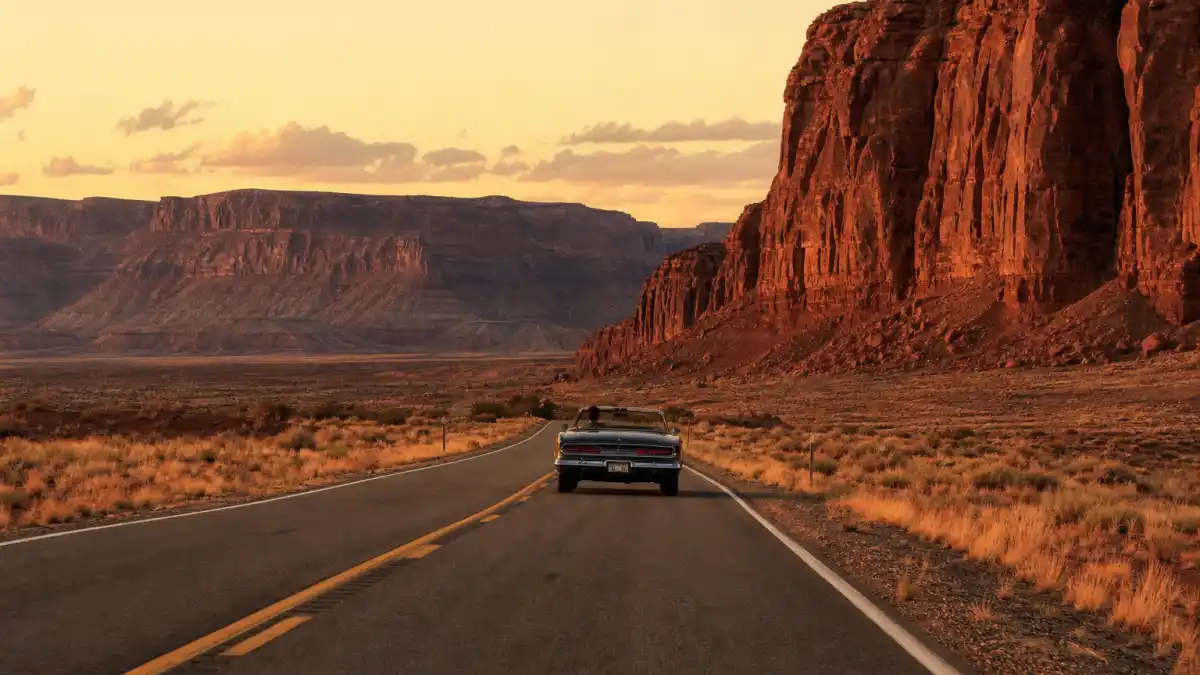 Where is Geena Davis now 2026 — desert highway with vintage convertible evoking Thelma and Louise road-movie icon era