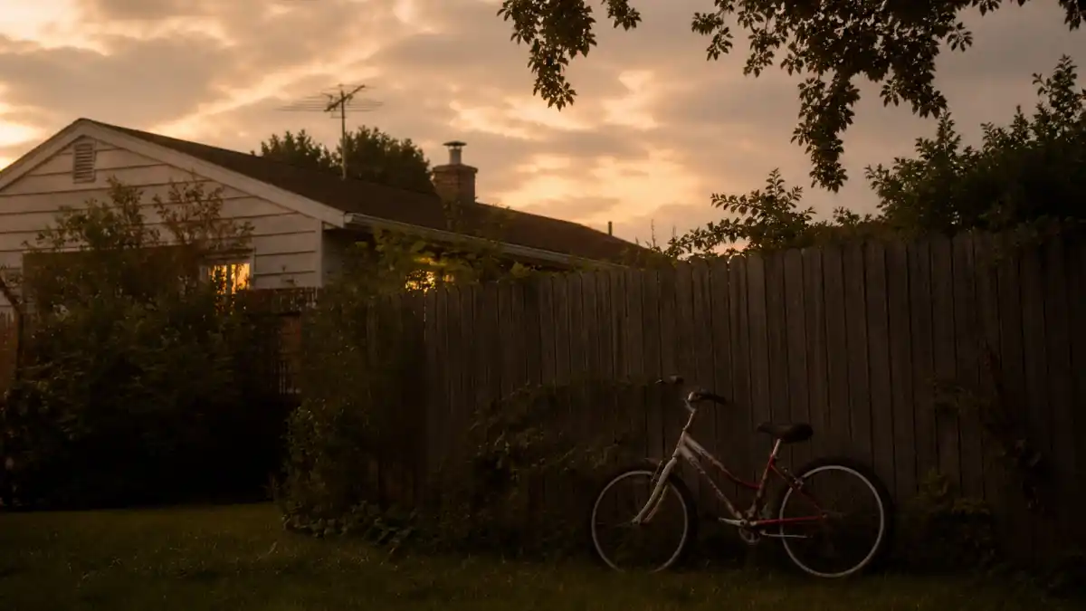 Where is Henry Thomas now — suburban 1980s backyard with bicycle and glowing sky evoking E.T. child star era