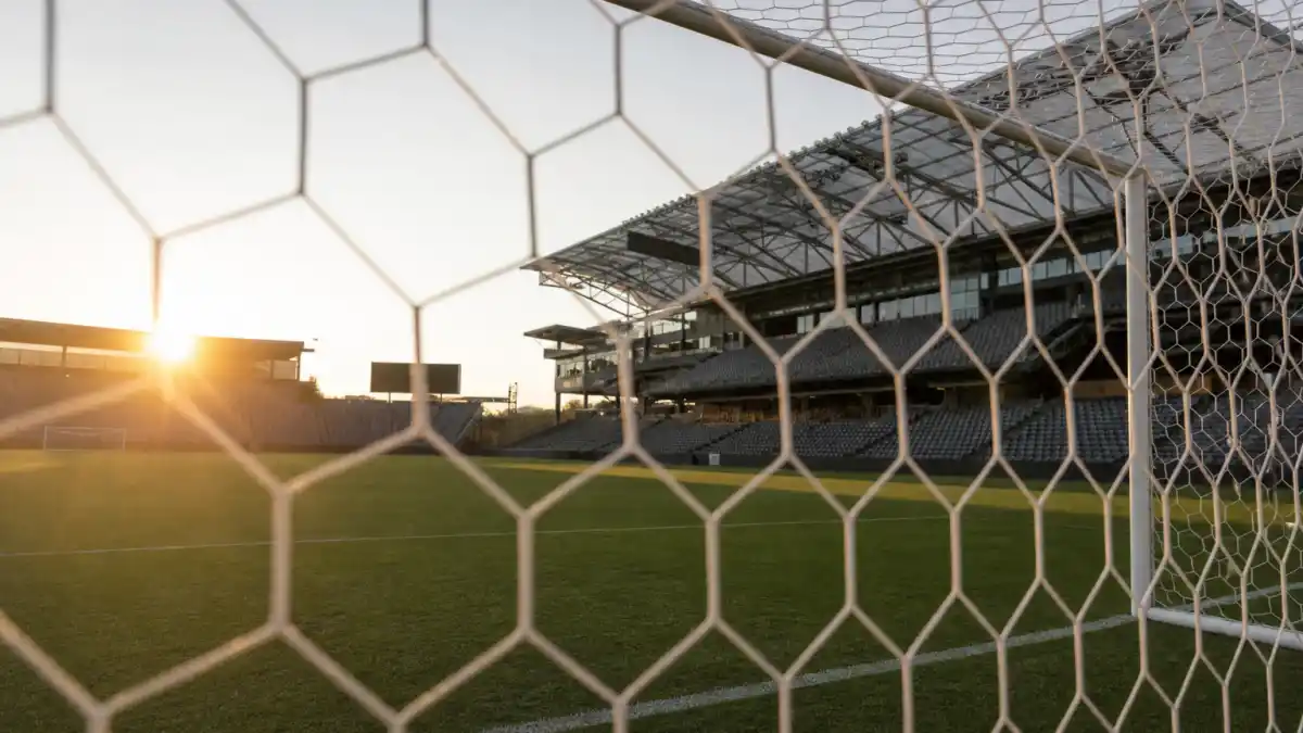 Where is Hope Solo now — empty women's soccer stadium at golden hour through goal net