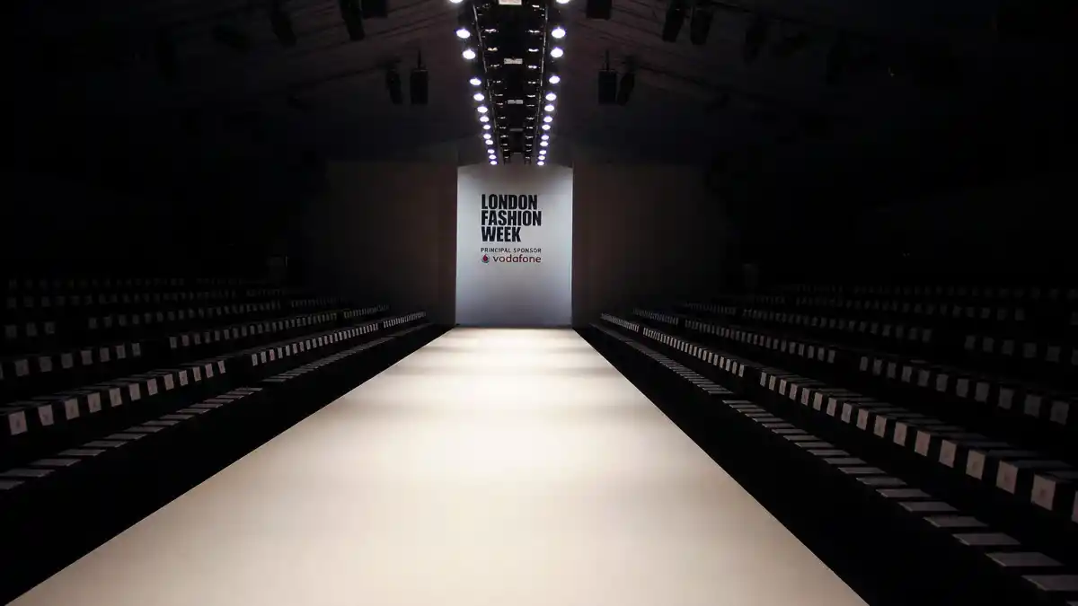 Where is Kate Moss now — empty London fashion runway with dramatic spotlights evoking British supermodel era
