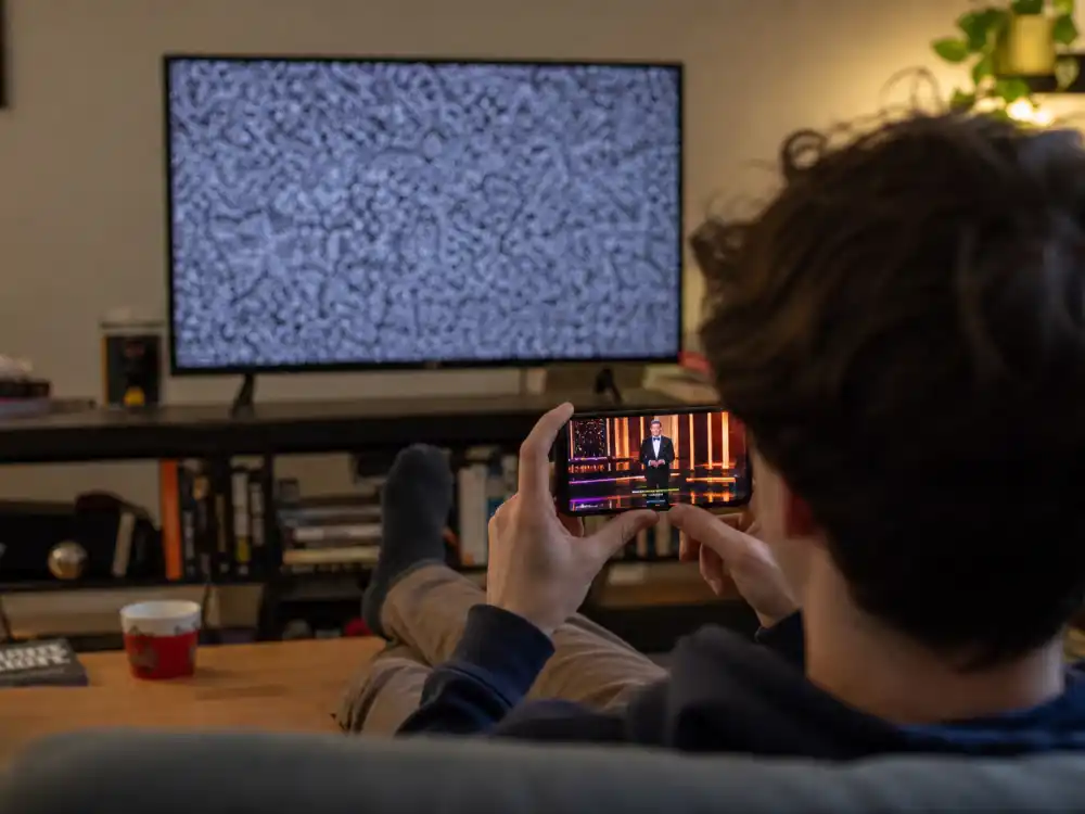 Young viewer watching award clips on phone while TV stays off reflects demographic shifts in why award show ratings are declining