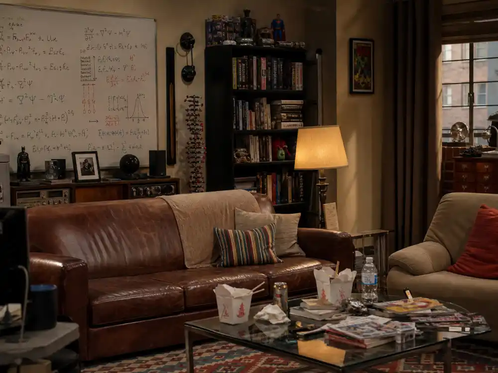 A geeky apartment living room with physics whiteboard evoking Wil Wheaton Big Bang Theory guest-star era