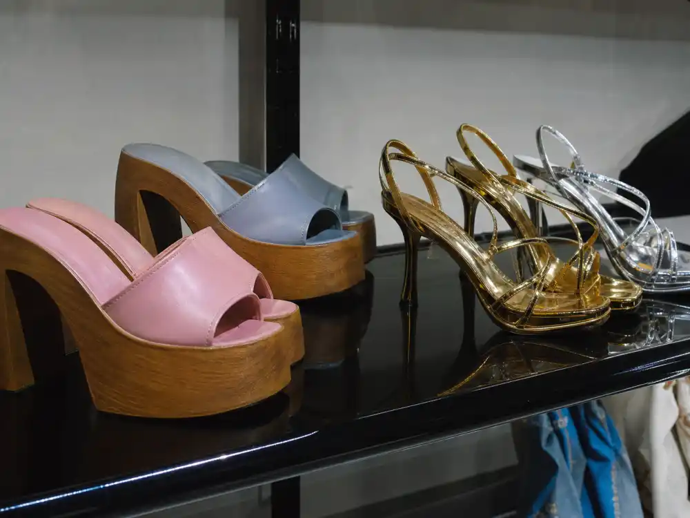 Chunky platform sandals and metallic strappy heels on boutique shelf defining Y2K celebrity fashion trend footwear elevation
