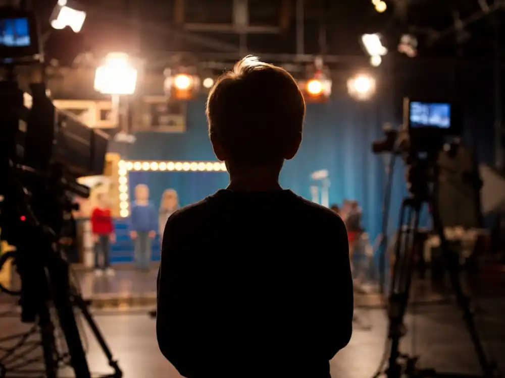 Anonymous child performer silhouette on a TV studio set captures the youth behind youngest Emmy winners ever acting milestones
