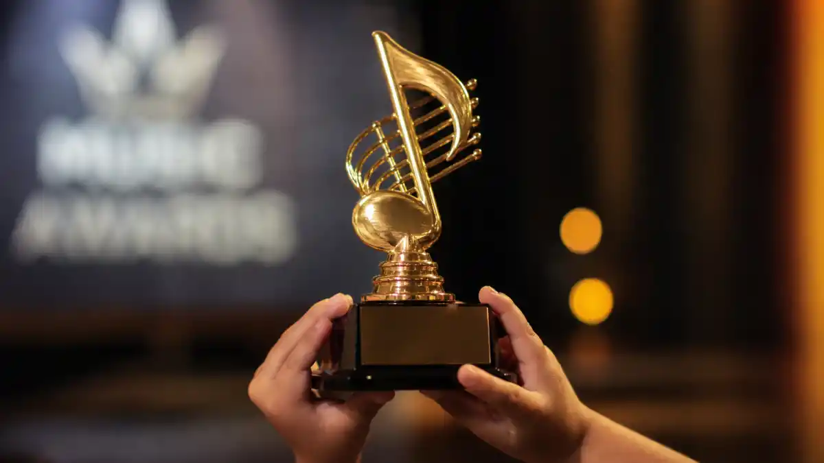 Youngest Grammy winners of all time — small hands holding a generic golden music trophy at a Recording Academy awards ceremony