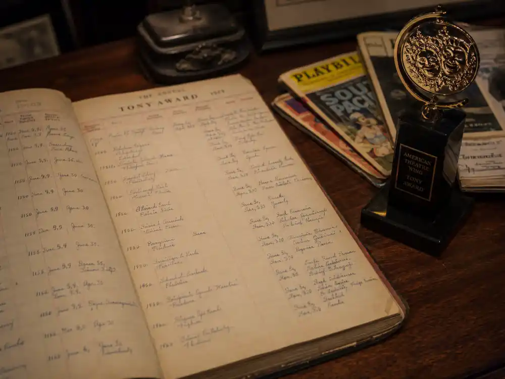 Broadway archive ledger beside golden Tony trophy tallies youngest Tony Award winners ever with verified ceremony birthdates