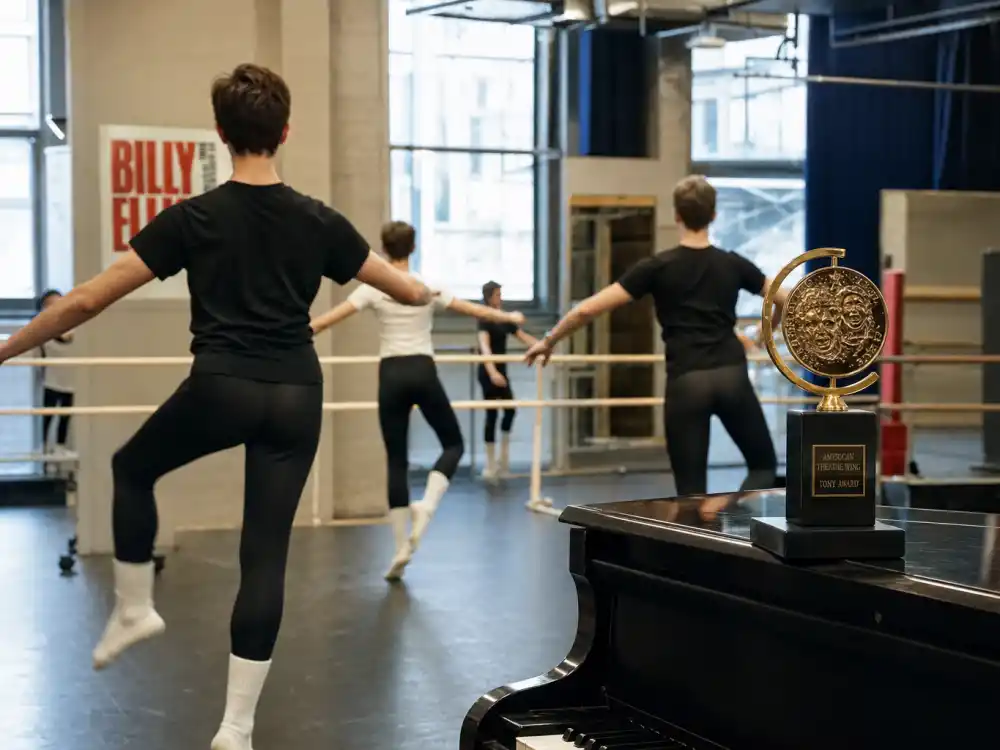 Broadway rehearsal studio with ballet barre and golden Tony Award reflecting youngest Tony Award winners ever Billy Elliot era youth performers
