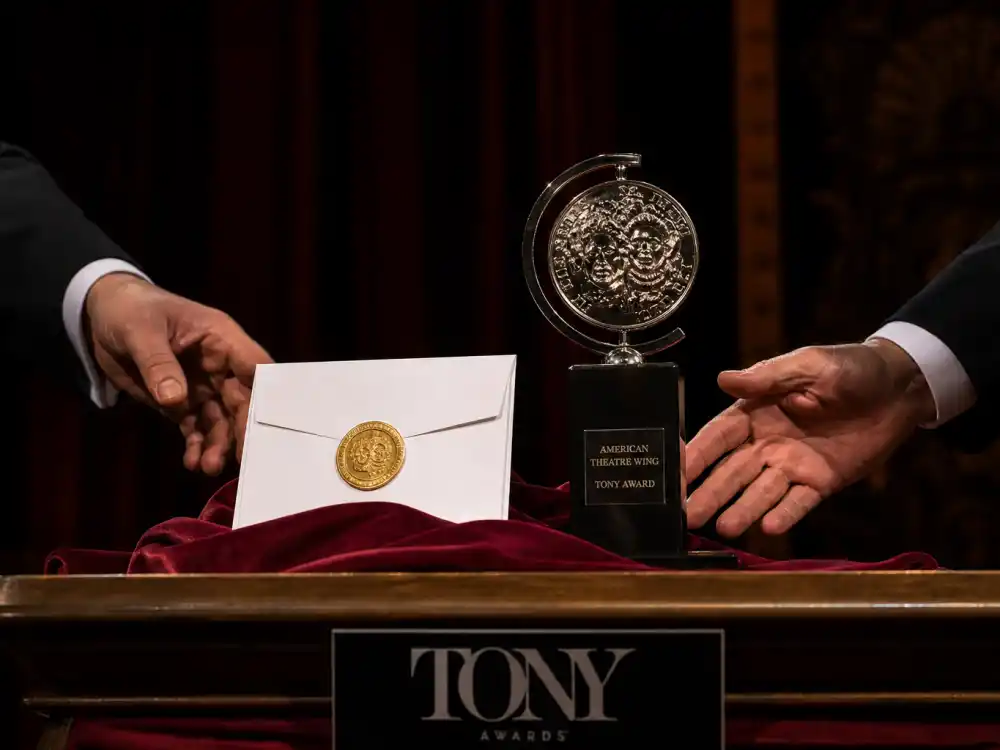 Tony Awards sealed envelope on podium beside golden statuette when youngest Tony Award winners ever accept competitive trophies each June