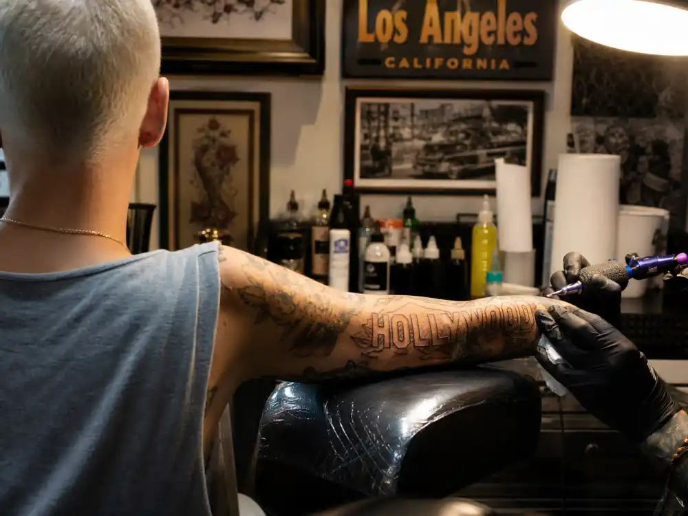 Amber Rose tattoos and their meanings — HOLLYWOOD sign lettering tattoo on left forearm photographed in Los Angeles studio