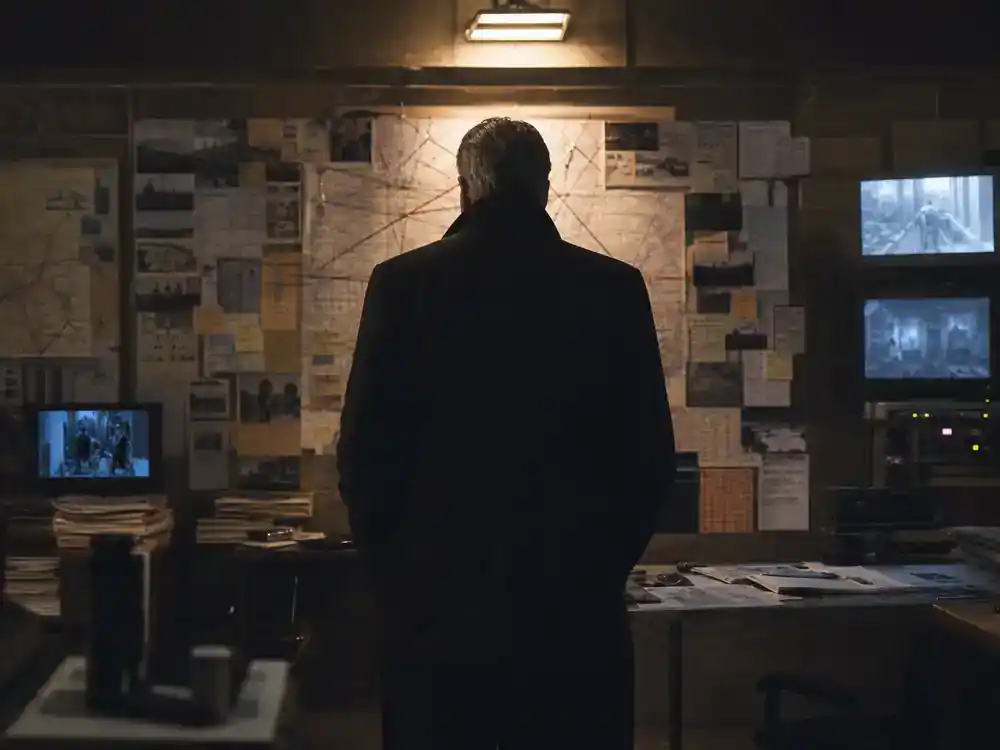 Andor season 2 cast and Star Wars timeline guide Stellan Skarsgård Luthen — actor silhouette from behind at rebel planning table in dim warehouse set