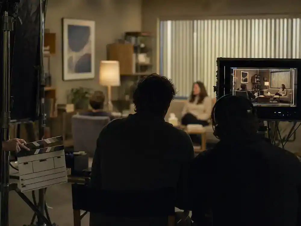 Apple TV Plus 2026 shows and cast guide Shrinking — therapy office TV set with actor silhouettes from behind on couch during comedy drama production