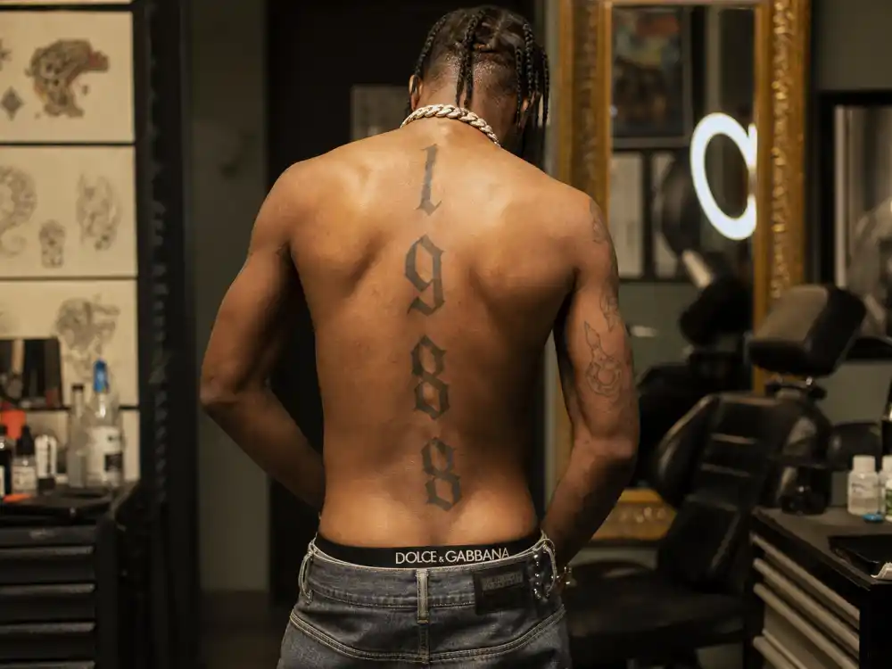 ASAP Rocky tattoos and their meanings — vertical 1988 spine tattoo matching Rihanna birth-year ink seen from behind